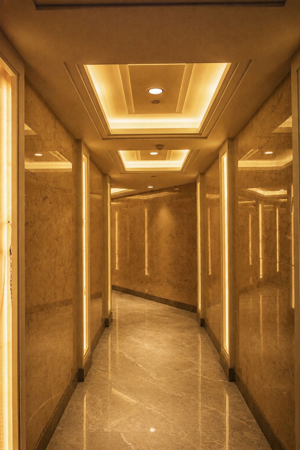 Hall em mármore com iluminação de nichos e cantoneiras